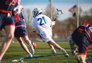 Close-up of lacrosse players' feet and sticks battling for possession during a game.