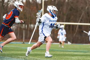 Side view of lacrosse players in action during a match on a sunny afternoon.