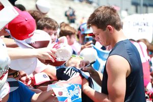 Football fans line up for autographs at a training camp session.