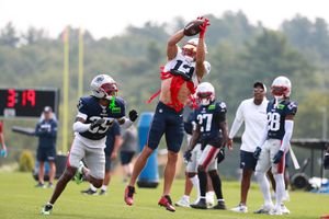 Football players jump high to catch the ball during a training session.