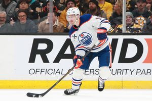 NHL hockey players battle for position along the boards during intense gameplay.
