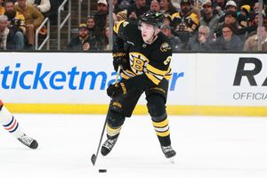 Hockey players from opposing teams compete for the puck during an NHL game.