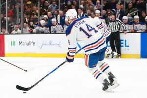 Professional hockey players skate across the ice during an intense NHL match.