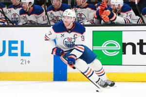 Professional hockey players skate down the ice during an NHL game.