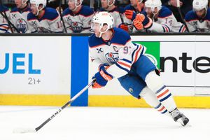 Hockey players from opposing teams chase after the puck during an NHL match.