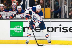Professional hockey players compete for puck control during an NHL game.