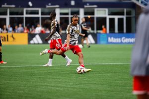 Soccer match in progress with players competing on professional field.
