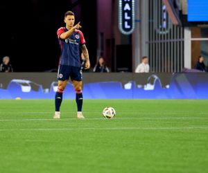 Soccer players position themselves strategically on a pristine grass field.