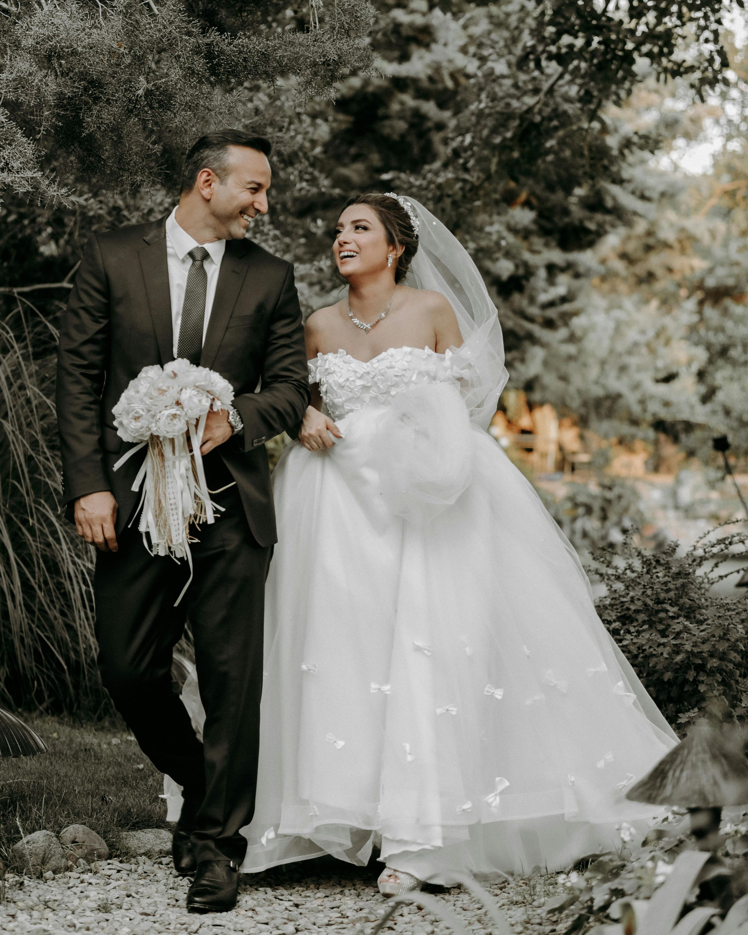 Outdoor wedding portraits capture romantic moments between newlyweds in a garden setting with bride in white gown.