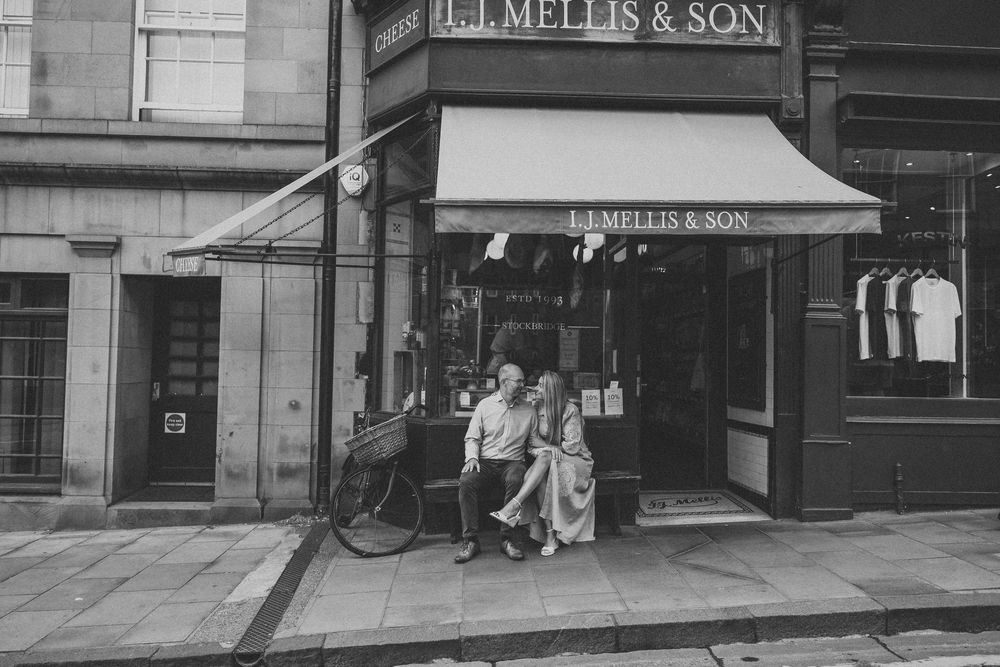 Vintage storefront of J. Mellis & Son shop with classic awning and window displays in black and white.