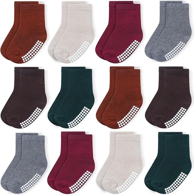 Collection of baby socks in brown, burgundy, gray, and white colors with non-slip grips arranged in neat rows.