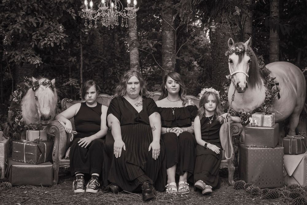 Group photo session with a white pony against a dark forest background.