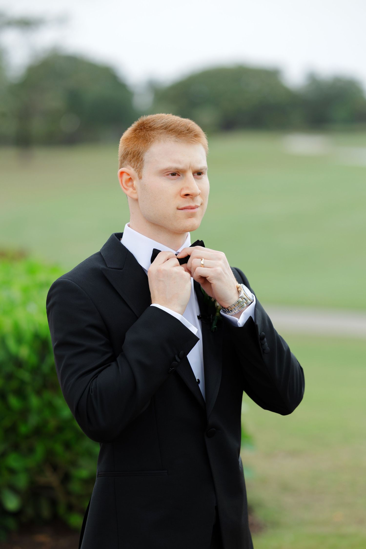 Groom adjusting tie at BallenIsles Country Club in Palm Beach during a wedding photographed by Ohio photographer Tom Forrest.