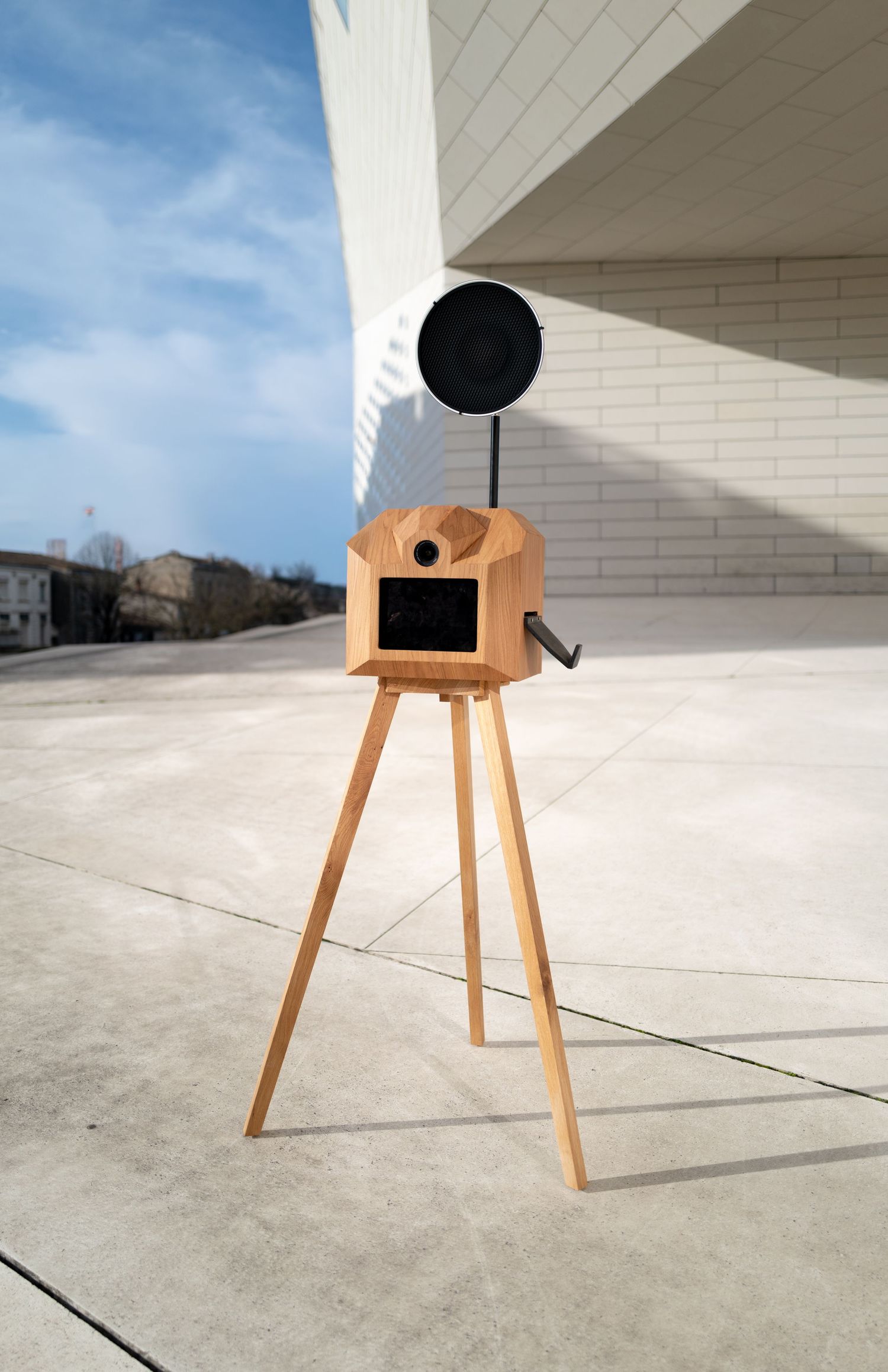 A sequence showing a wooden three-legged stool with a black circular top photographed from different angles on concrete.