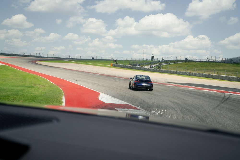 Panoramic view of a racing circuit with red and white track boundaries.