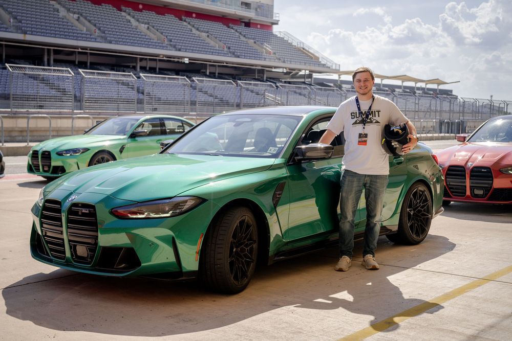 Green BMW M4 sports cars lined up at a racing facility.