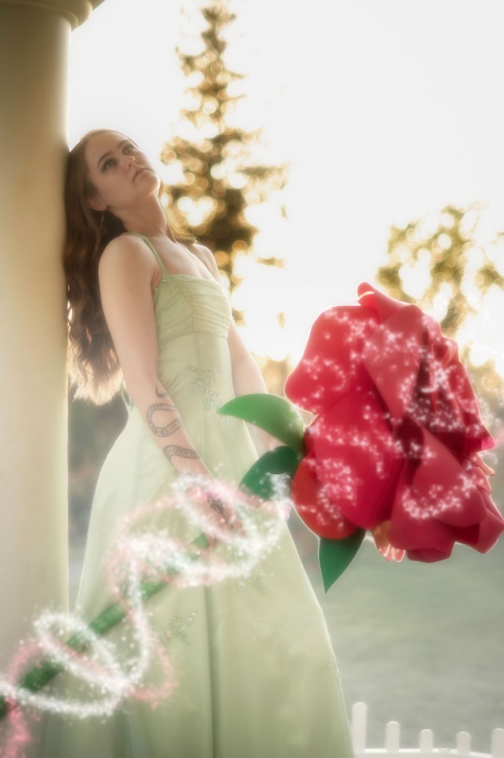Dreamy fantasy photoshoot with a rose prop during golden hour in the Rose Garden At Manito Park in Spokane Washington.