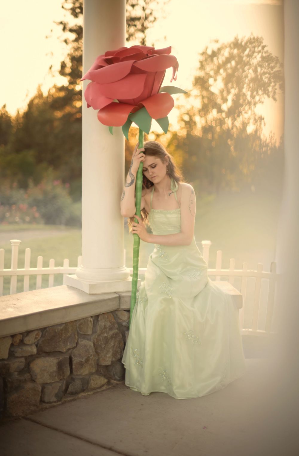 Dreamy fantasy photoshoot with a rose prop during golden hour in the Rose Garden At Manito Park in Spokane Washington.