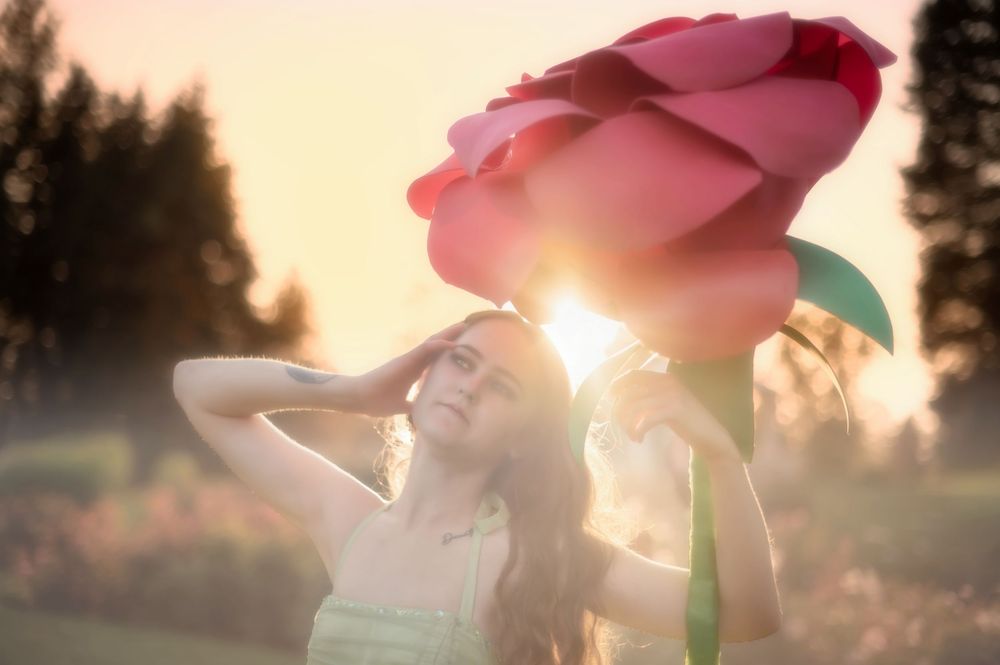 Dreamy fantasy photoshoot with a rose prop during golden hour in the Rose Garden At Manito Park in Spokane Washington.