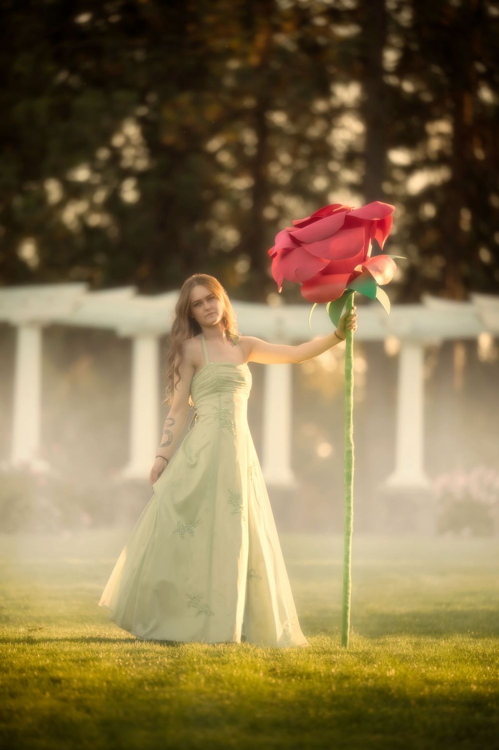 Dreamy fantasy photoshoot with a rose prop during golden hour in the Rose Garden At Manito Park in Spokane Washington.