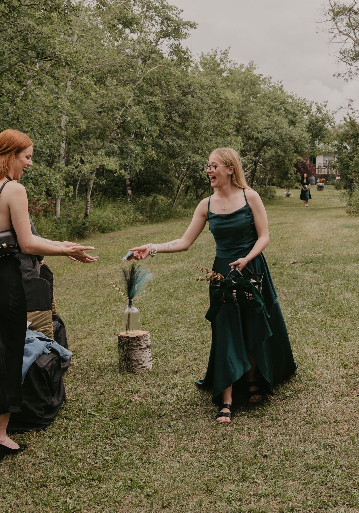 Wedding party members in dark dresses playing lawn games outdoors.