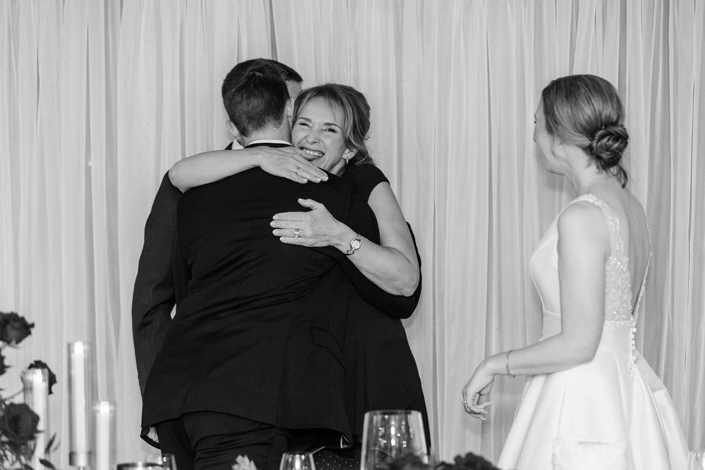 Black and white photo of couples dancing together at a formal event with curtains in the background.
