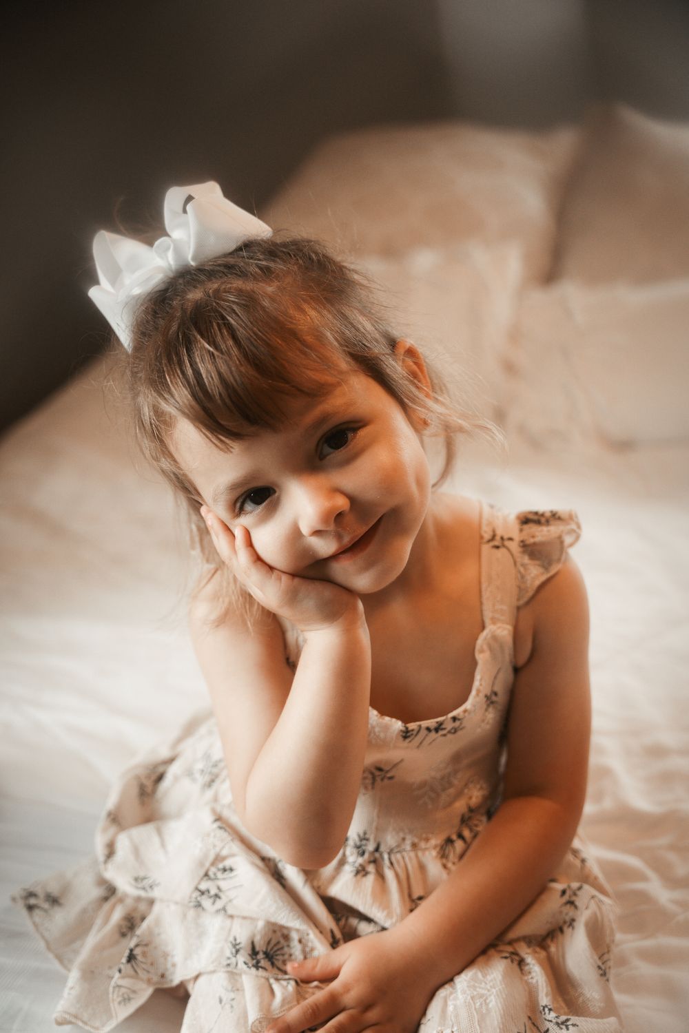 A young child wearing a delicate pink tulle dress poses gracefully in a series of dreamy portraits at family lifestyle session in Northbrook