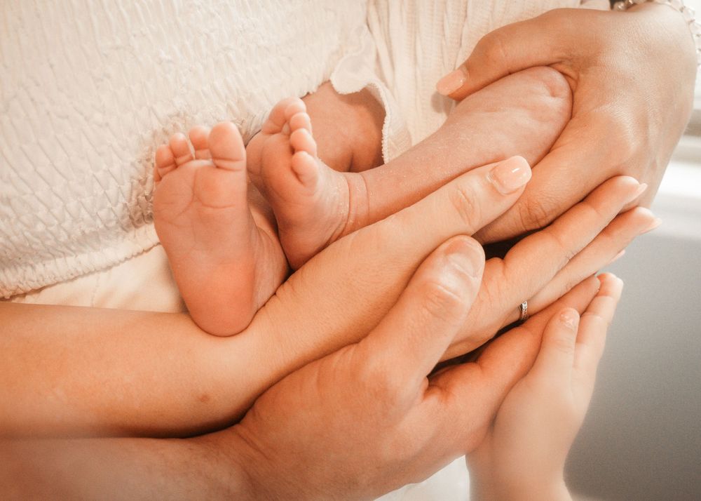 Newborn session featuring family's hands holding a baby in Northbrook