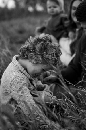 Black and white close-up of curly hair blowing in the wind with a delicate lace pattern visible during family session in Palatine