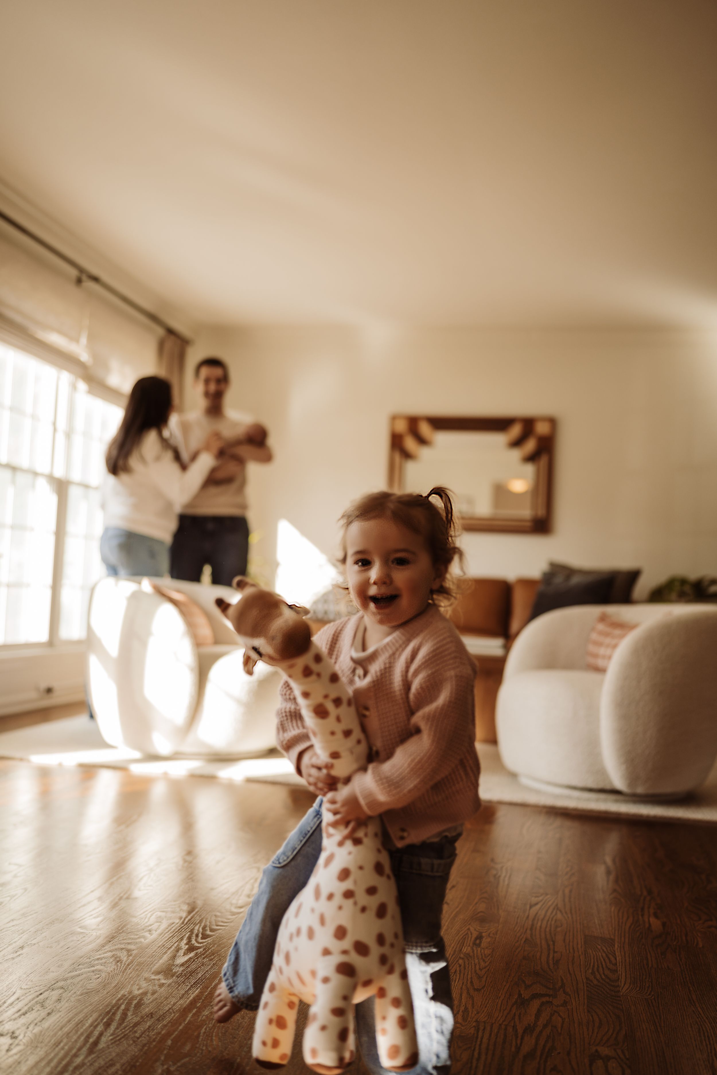 A little girl with her family behind at their family lifestyle session with a newborn in Rolling Meadows