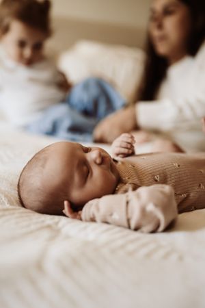 A series of soft focus images showing a baby's tiny feet resting on white bedding in natural light.