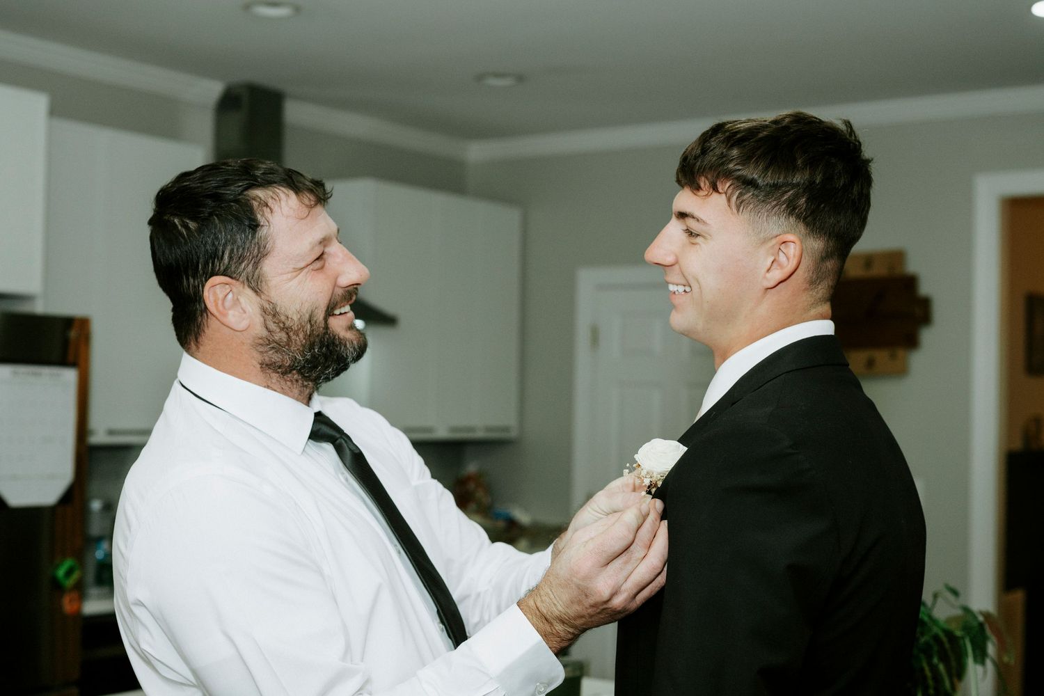 People in white dress shirts laughing and socializing at an indoor gathering.