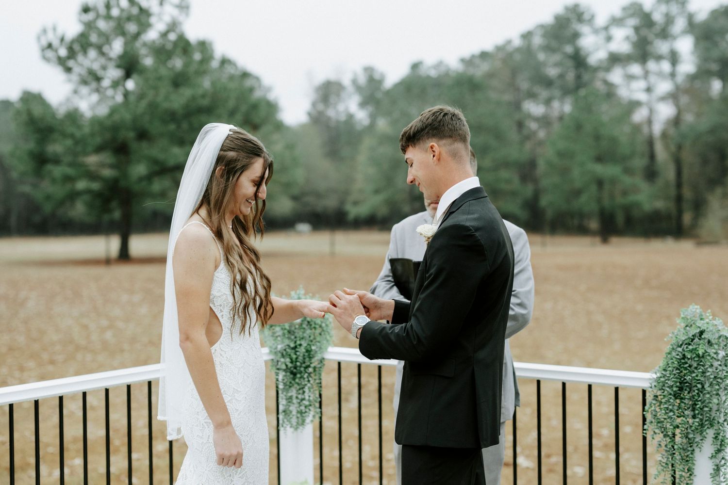A couple shares intimate moments during their outdoor wedding ceremony in a rustic countryside setting.