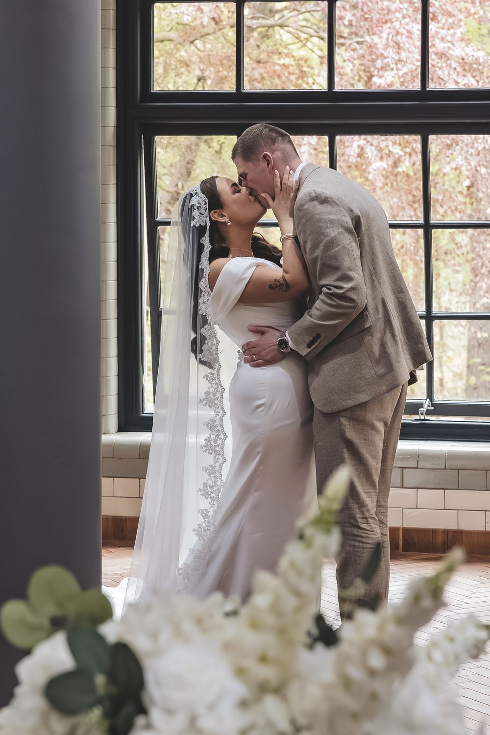 Natural first kiss wedding photo of bride and groom on their wedding day.