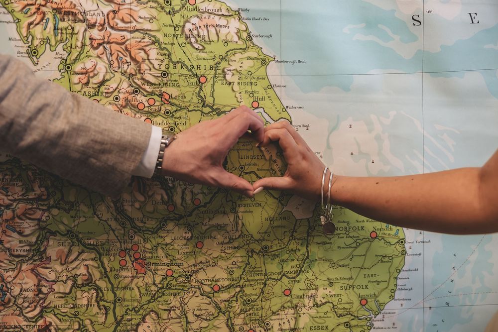 Relaxed posed heart shape made by bride and groom over the location they first met.