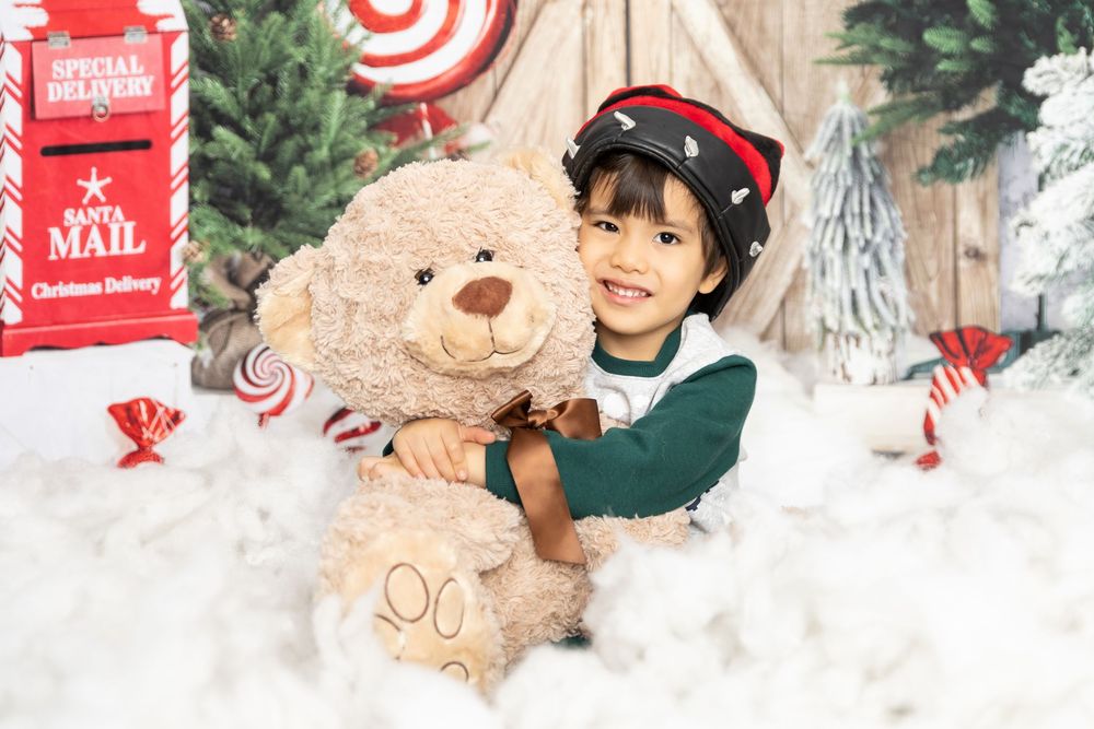 A festive Christmas scene with red and white decor, evergreen branches, and holiday ornaments arranged on white snow.