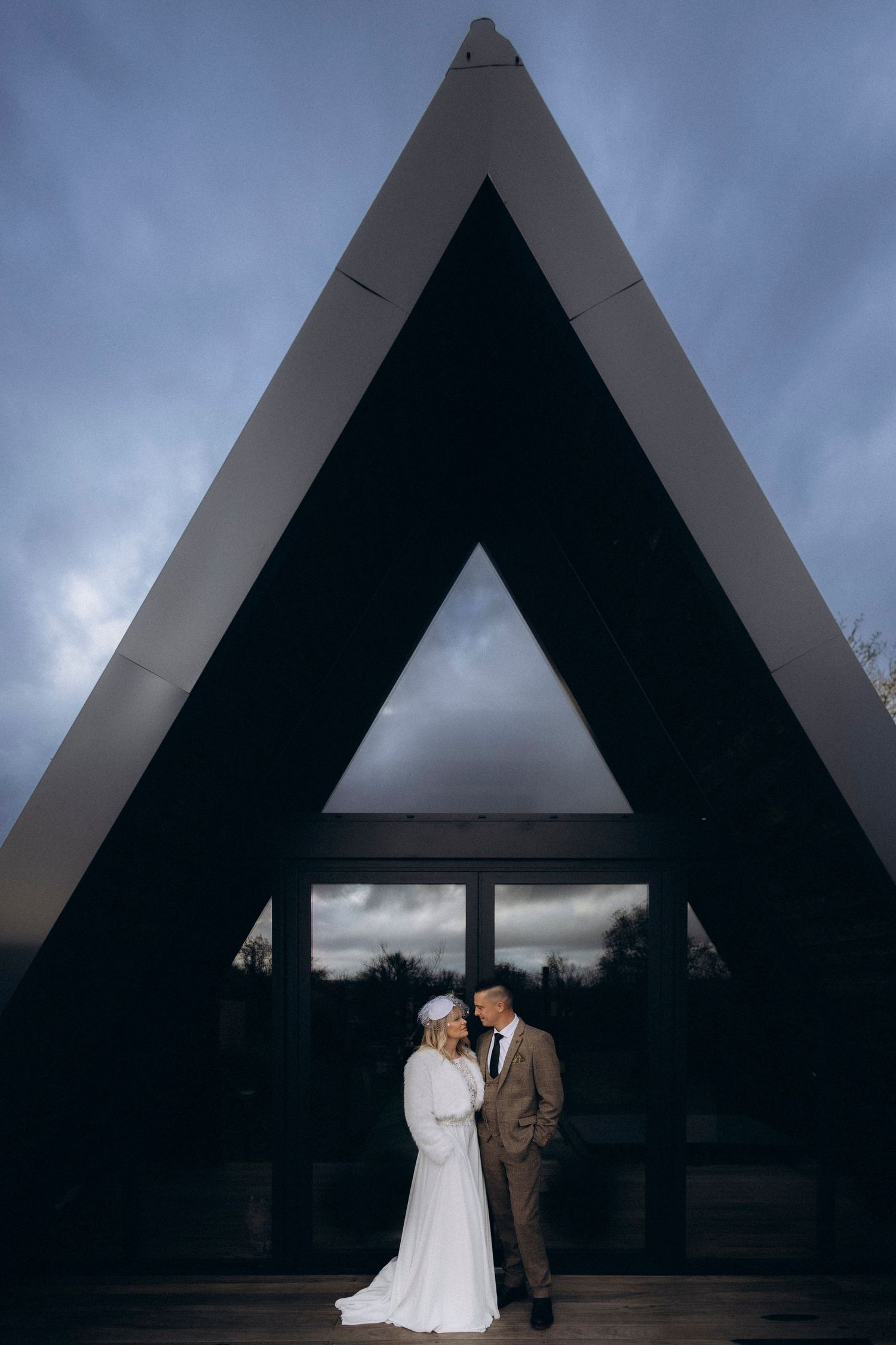 A tender autumn embrace captured during a wedding photoshoot with fall foliage.