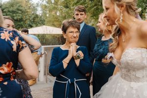 Wedding guests hold up their phones to capture a special moment during an outdoor ceremony.