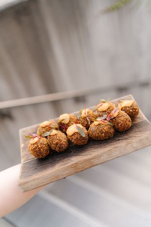 Homemade falafel balls garnished with cashews and spices served on a rustic wooden serving board.