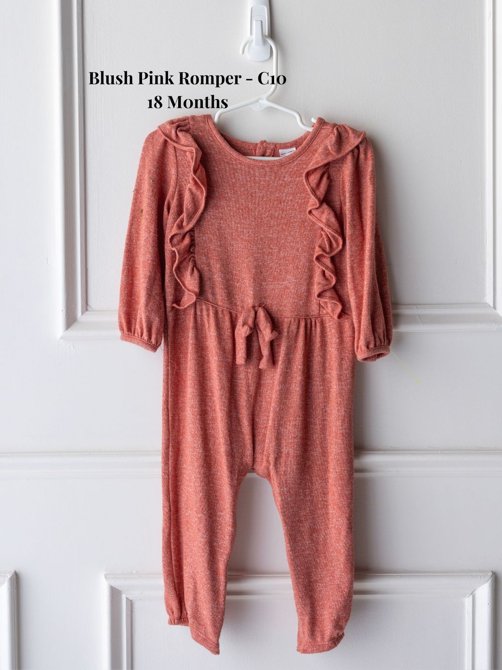 Soft pink baby romper with ruffled shoulder details and long sleeves shown in multiple angles on white background.