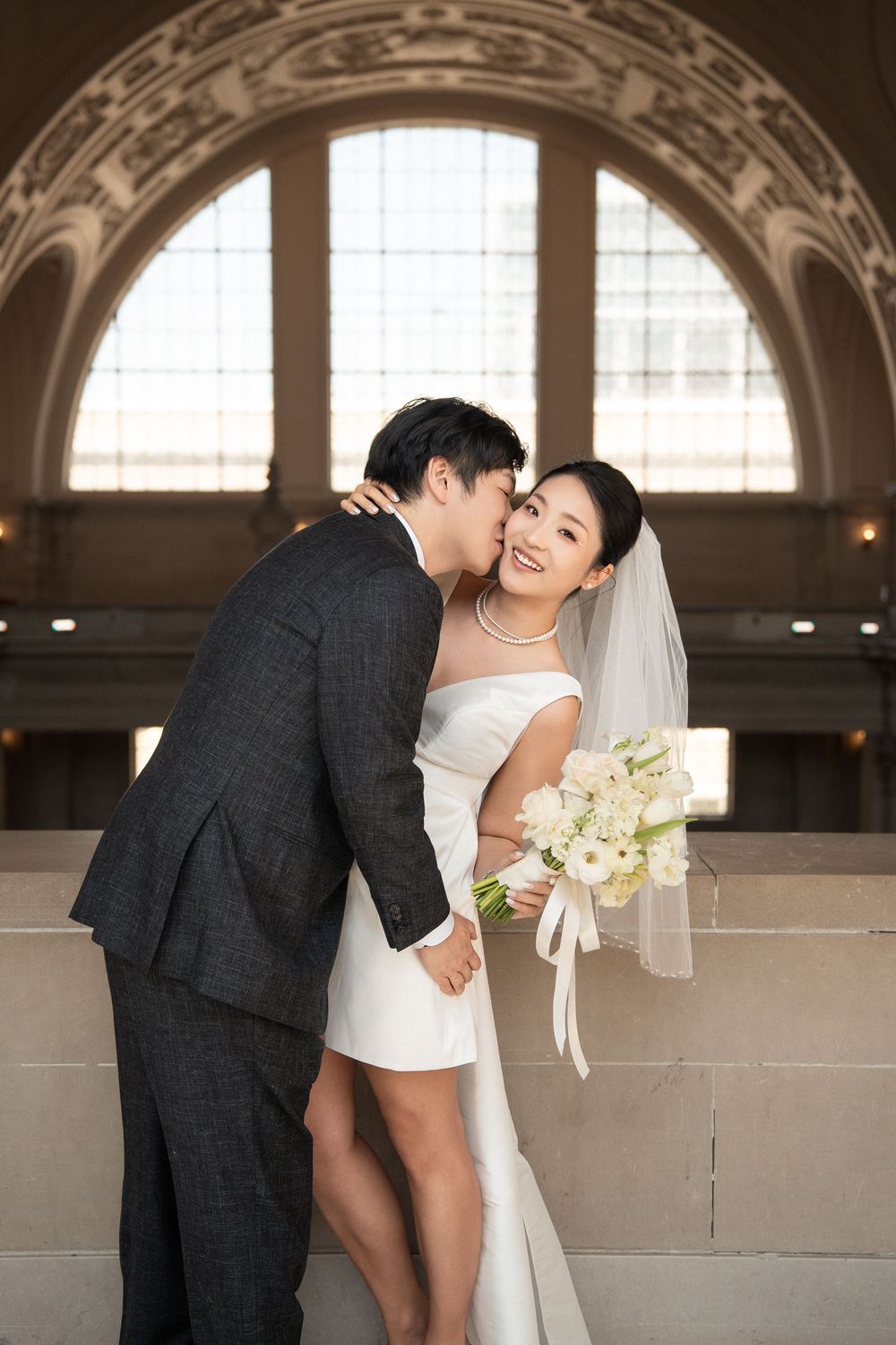 Romantic wedding photo sequence showing tender moments against an elegant architectural backdrop.