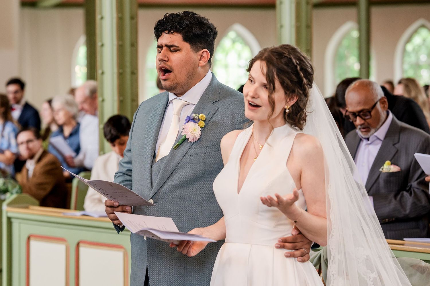 Bruid en bruidegom zingen tijdens ceremonie, vastgelegd door christelijke trouwfotograaf in Blaricum