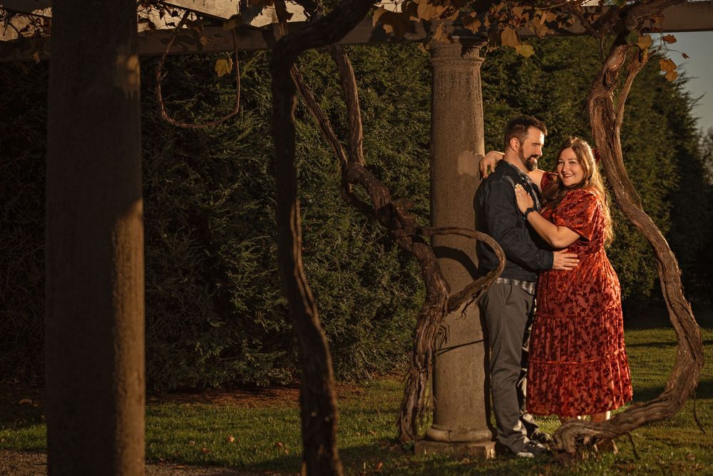 Golden sunset light illuminates trees and columns in a romantic outdoor setting.