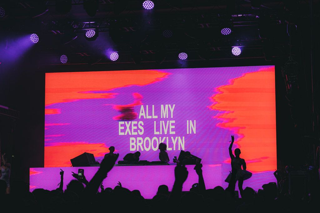 A silhouetted cityscape against a vibrant pink and purple sky with text overlaid in white lettering.