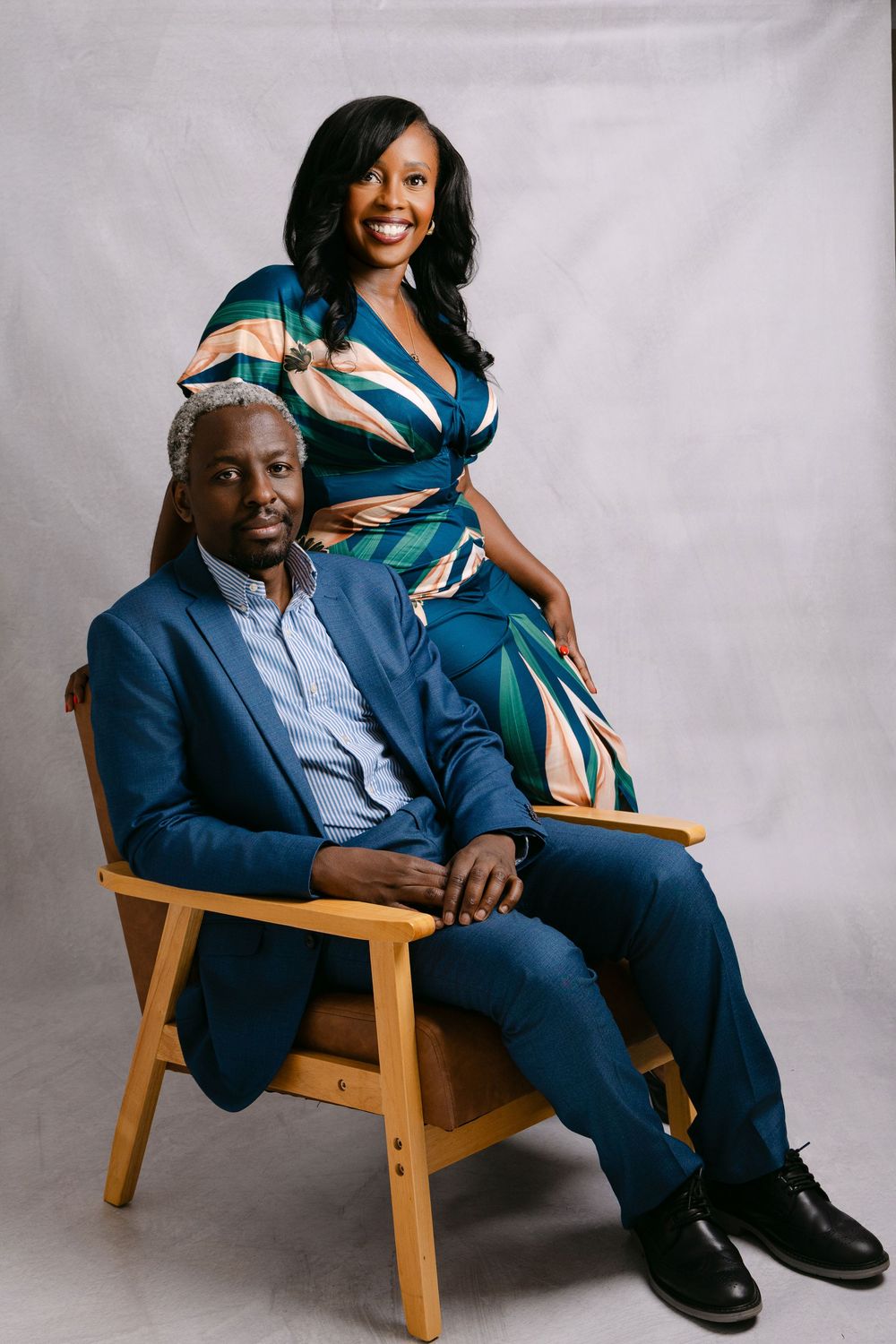 Elegant couple poses on wooden chair during professional studio photoshoot in Fremantle