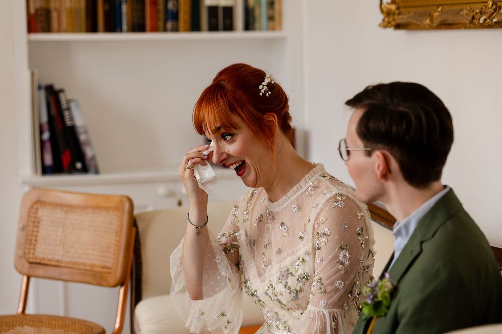 A couple shares a joyful moment during their wedding celebration in an elegant indoor setting.