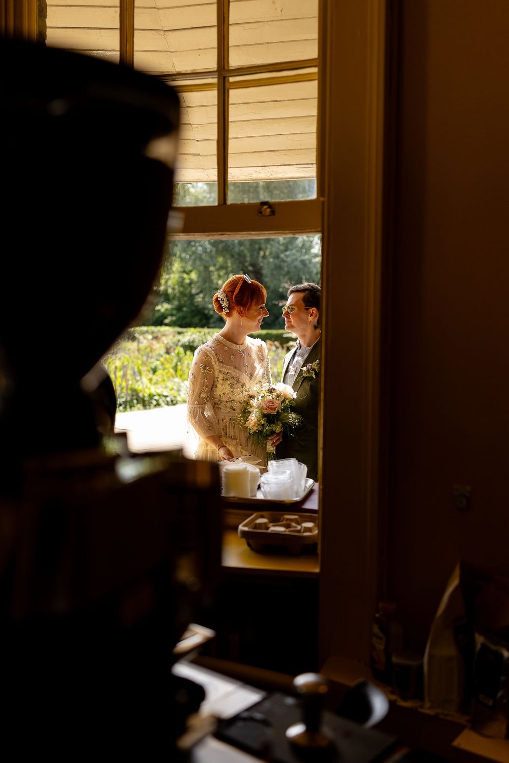 Silhouetted figures seen through a window in warm golden afternoon light.