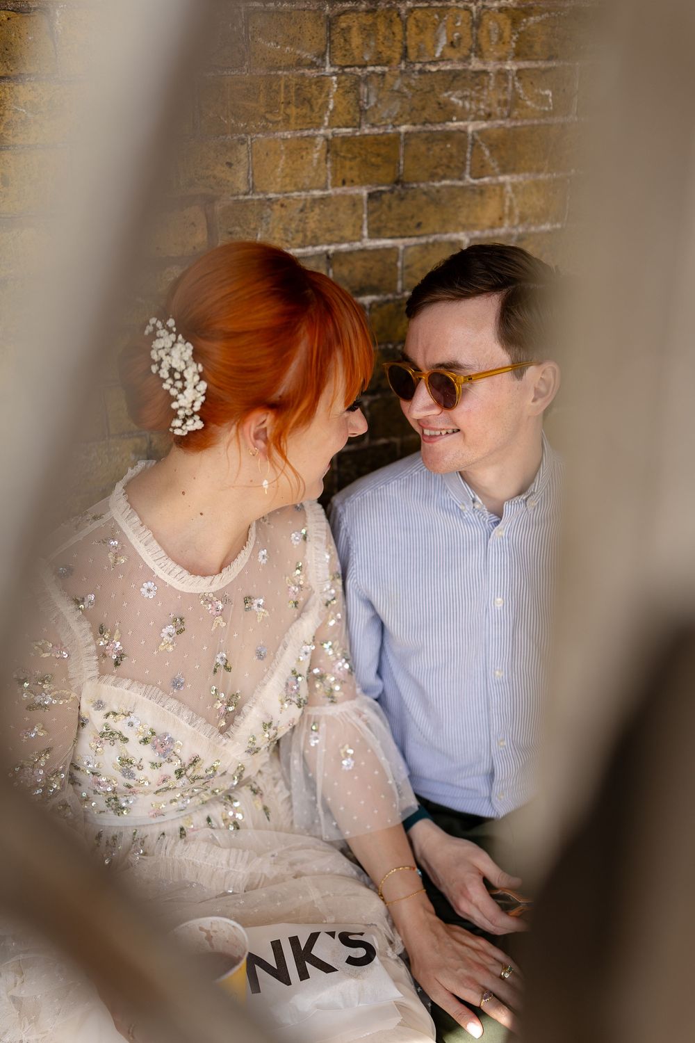Intimate portraits showing tender moments between a couple against a textured brick wall background.