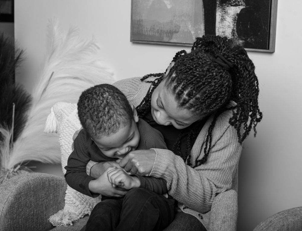 A tender moment captured in black and white as two people share a close embrace while sitting together.