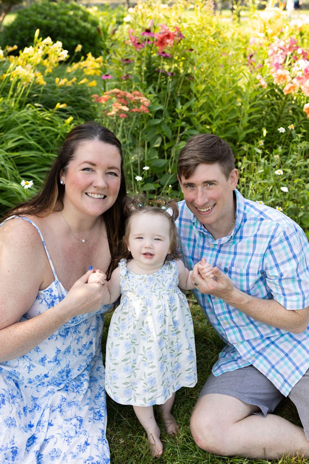 Family relaxing together in a colorful flower garden during summer. Spring Mini Session